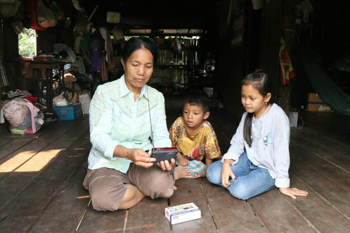 A woman and two children sitting on the floor